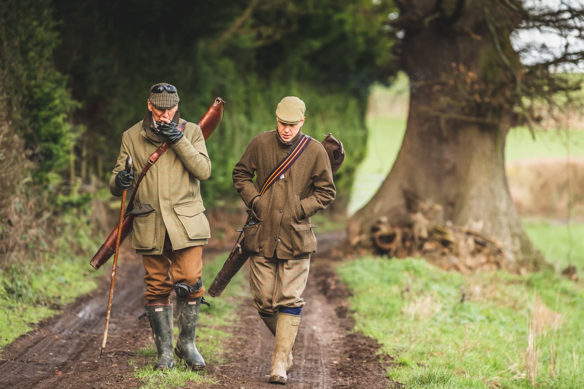 Two guns walking a muddy estate track between drives